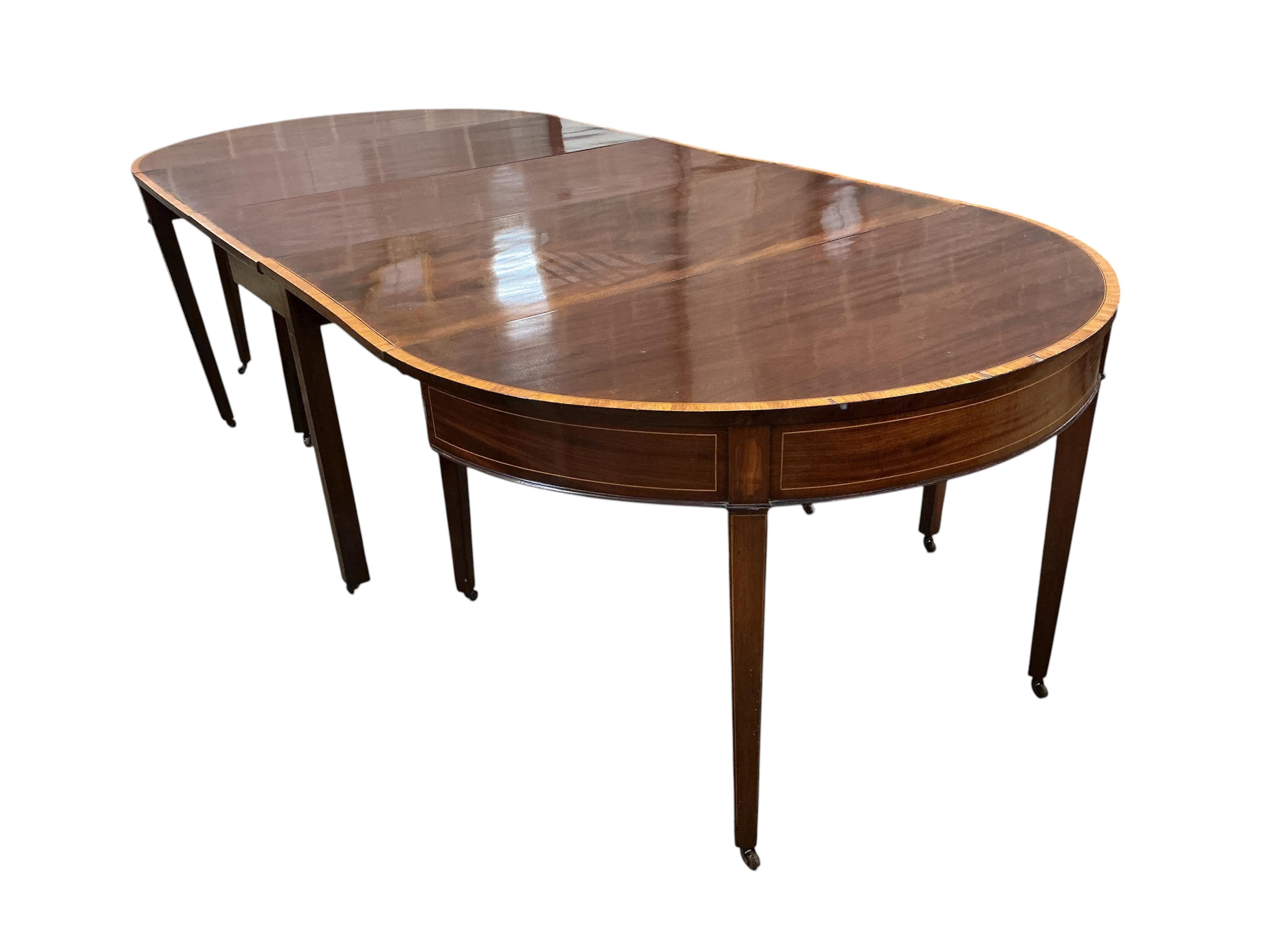 A George III satinwood banded mahogany D end extending dining table, with two spare leaves, 284cm extended, depth 120cm, height 74cm, together with a set of eight Victorian mahogany balloon back dining chairs